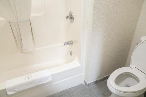 a white bathroom with a toilet and a bath tub at Quality Inn Seymour I-65 in Seymour