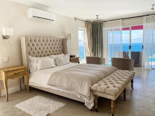 um quarto com uma cama grande e uma janela grande em Residence William French em Simonʼs Town