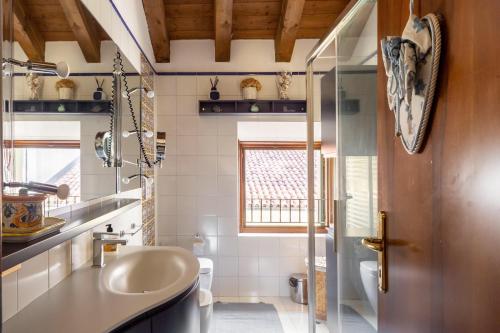 baño con lavabo y aseo y ventana en Via Calcada Apartment, en Vittorio Veneto