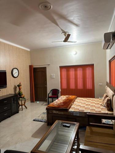 Habitación con 2 camas y reloj en la pared en Kaashi Flora (Full Villa - 5 Bedrooms), en Varanasi