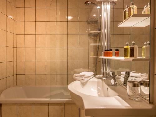 une salle de bain avec un lavabo et une baignoire dans l'établissement Appartement spacieux pour 6, proche pistes et centre aquasportif à Val-d'Isère - FR-1-694-194, à Val dʼIsère