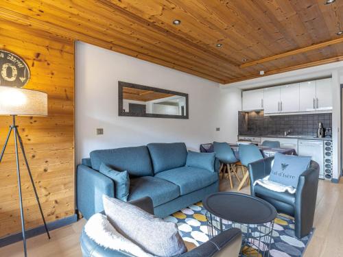 un salon avec un canapé bleu et des chaises dans l'établissement Appartement élégant à Val-d'Isère avec balcon, parking, wifi - FR-1-694-270, à Val dʼIsère