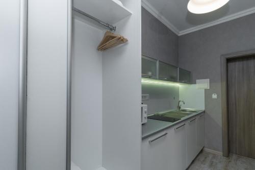 a kitchen with white cabinets and a sink at Opera Passage Hotel & Apartments in Lviv