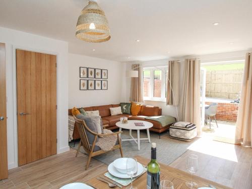 a living room with a couch and a table at Waterston Cottage in Wareham
