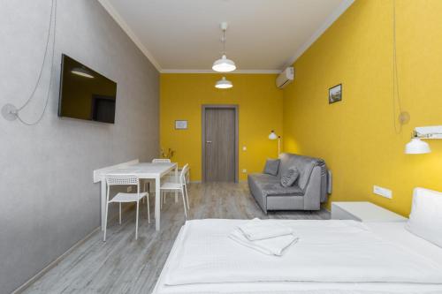a room with a bed and a table and a couch at Opera Passage Hotel & Apartments in Lviv