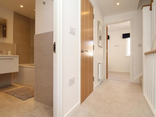 een hal met een deur naar een badkamer bij Waterston Cottage in Wareham