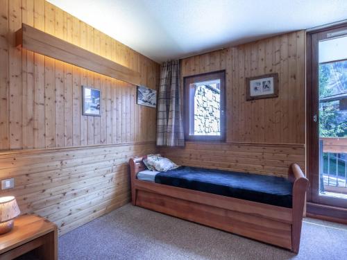 a room with a bed in a wood paneled room at Appartement Val-d'Isère, 2 pièces, 4 personnes - FR-1-694-284 in Val-d'Isère