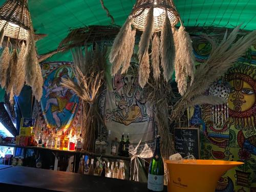 a bar with a decorated wall with a bar with dried plants at guinguette pour faire la fête in Saint-Laurent-dʼAigouze