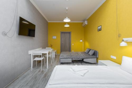 a room with two beds and a table and a yellow wall at Opera Passage Hotel & Apartments in Lviv