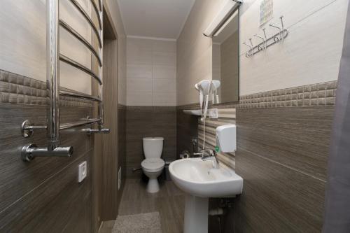 a bathroom with a toilet and a sink at Opera Passage Hotel & Apartments in Lviv
