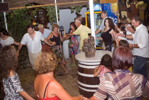 a group of people standing around a wine barrel at XeniCamp & Bungalows in Tolo