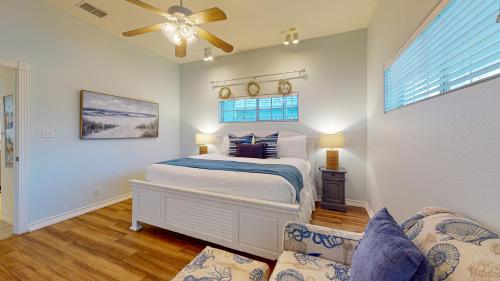 1 dormitorio con 1 cama y ventilador de techo en FD115 Spacious Home in Royal Sands, Shared Pool & Hot Tub, Golf Cart Included, Beach Boardwalk en Port Aransas