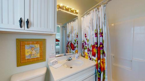 y baño con lavabo y espejo. en FD115 Spacious Home in Royal Sands, Shared Pool & Hot Tub, Golf Cart Included, Beach Boardwalk en Port Aransas