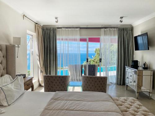 a bedroom with a bed and a view of the ocean at Residence William French in Simonʼs Town