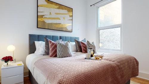una camera bianca con un grande letto con cuscini di Samdel Dulwich Grove 3 Bed Apartment a Londra