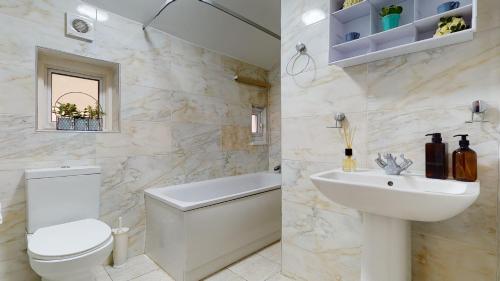 a white bathroom with a toilet and a sink at Samdel Dulwich Grove 3 Bed Apartment in London