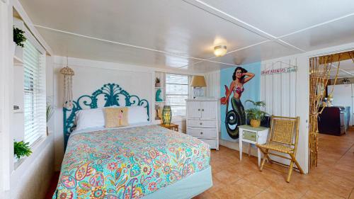 a bedroom with a bed and a painting of a woman at NS731 Coastal Cottage, In Town Near Shops, Restaurants and Nightlife in Port Aransas
