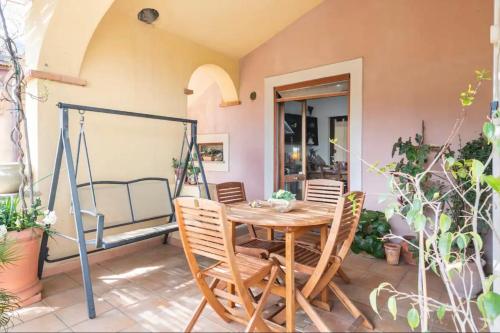 een patio met een houten tafel en stoelen bij B&B Su Biancu - Sardinian Experience in Urzulei