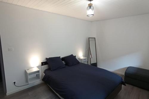 sypialnia z niebieskim łóżkiem z 2 poduszkami w obiekcie Gîte les Rayols w mieście Saint-Agrève