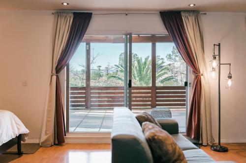 - un salon avec un canapé et une grande fenêtre dans l'établissement Tierra Mia Hacienda Ruta del Vino, à Valle de Guadalupe