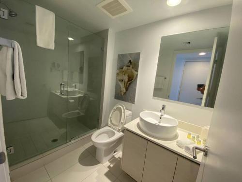 Un baño con lavabo, inodoro y ducha. en Walk to the Waves, 2 Full Bed Beach Studio Stay, en Hallandale Beach