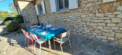 a table with chairs and a blue table cloth at Les Pierres de Cézaire in Saint-Cézaire-sur-Siagne