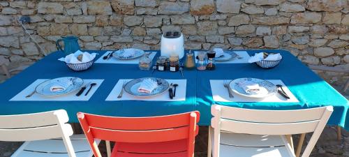 a blue table with chairs and plates on it at Les Pierres de Cézaire in Saint-Cézaire-sur-Siagne