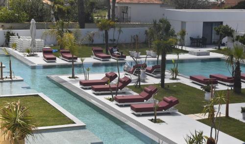 een leeg zwembad met ligstoelen in een resort bij Maro Apartments Arillas Corfu in Arillas