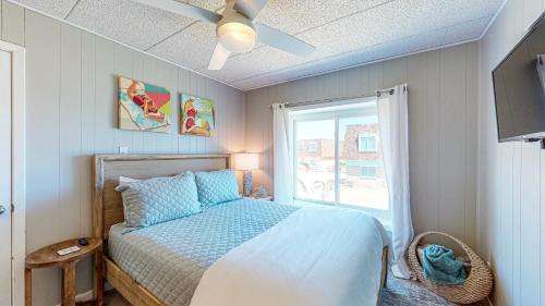 a bedroom with a bed with a ceiling fan and a window at IR104 3BR Condo w Gulf View, Shared Pools, Boardwalk in Port Aransas