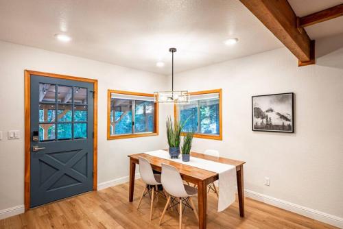 a dining room with a table and a blue door at Corlieu Falls Cabin in Sugar Pine 8 miles from Yosemite with Gazebo, Hot tub a shack and Bar top in Oakhurst