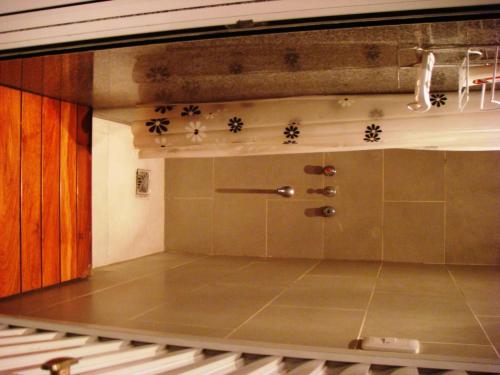 a bathroom with a shower and a tile floor at Hagoth Hostel in Buenos Aires