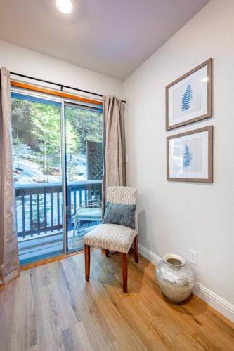 a living room with a chair and a balcony at Corlieu Falls Cabin in Sugar Pine 8 miles from Yosemite with Gazebo, Hot tub a shack and Bar top in Oakhurst