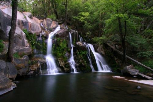 a waterfall in the middle of a pool of water at Corlieu Falls Cabin in Sugar Pine 8 miles from Yosemite with Gazebo, Hot tub a shack and Bar top in Oakhurst