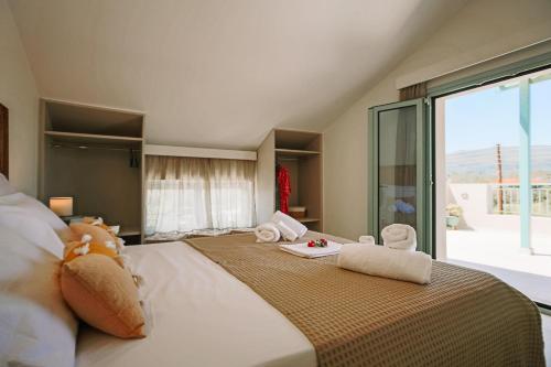 a bedroom with a large bed with towels on it at Melior Holiday Houses in Laganas