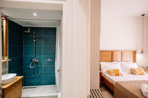 a bathroom with a bed and a shower and a sink at Melior Holiday Houses in Laganas