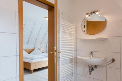 a bathroom with a sink and a mirror at Straendhus Bed&Breakfast in Hasselberg