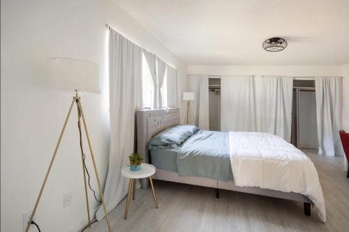 una camera con letto e tavolo con lampada di Serenity Studio a Fort Pierce