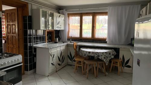 uma cozinha com uma mesa e algumas cadeiras em Stary Bór em Murzasichle