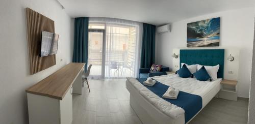 a bedroom with a large bed with a blue headboard at Complex Sea Star 2Mai in 2 Mai