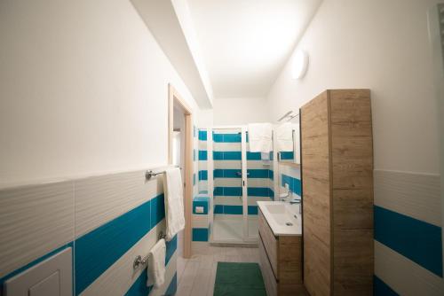a bathroom with blue and white stripes on the walls at 10 e Lode in Mazara del Vallo
