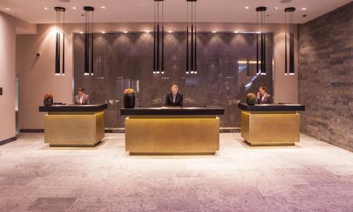 a lobby with three people sitting at reception desks at AlpenGold Hotel Davos in Davos