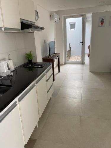 聖佩德羅的住宿－Estudio，厨房配有白色橱柜和黑色台面