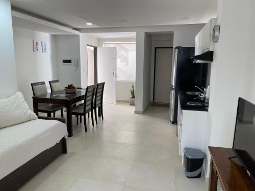 聖佩德羅的住宿－Estudio，厨房以及带桌子和沙发的客厅。