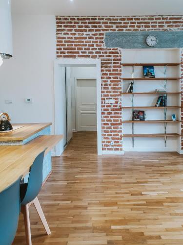 a room with a brick wall and a wooden floor at Priestranný apartmán v centre in Košice