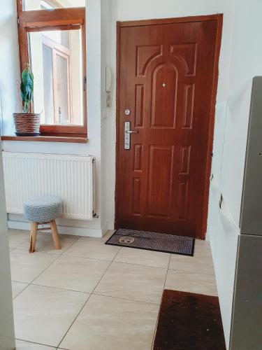 a wooden door in a room with a window at Priestranný apartmán v centre in Košice