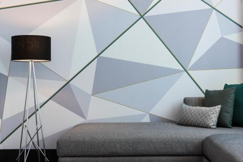 a living room with a couch and a geometric wall at Warwick Le Crystal - Montréal in Montréal