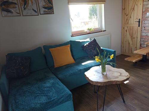 a blue couch in a living room with a table at Mazurska Łąka in Piecki