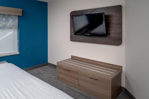 a bedroom with a bed and a tv on a wall at Holiday Inn Express - Charleston/Kanawha City by IHG in Charleston