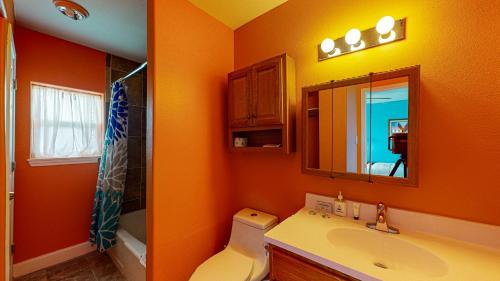 Baño de color naranja con lavabo y espejo en SIV10 Beautiful Condo, Shared Pool, Close to Beach en Port Aransas
