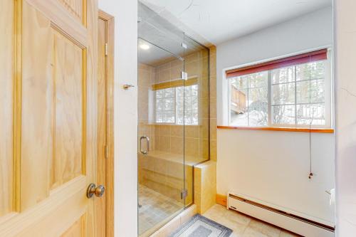 een badkamer met douche en glazen deur bij Wapiti Point - Main House in Grand Lake